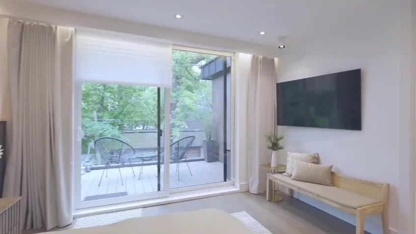 Bedroom with pot lights and a walkout balcony in a custom home build